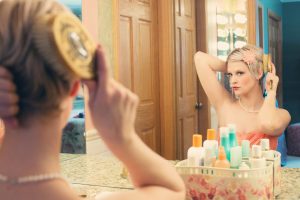 foto de una mujer peinándose delante de un espejo grande